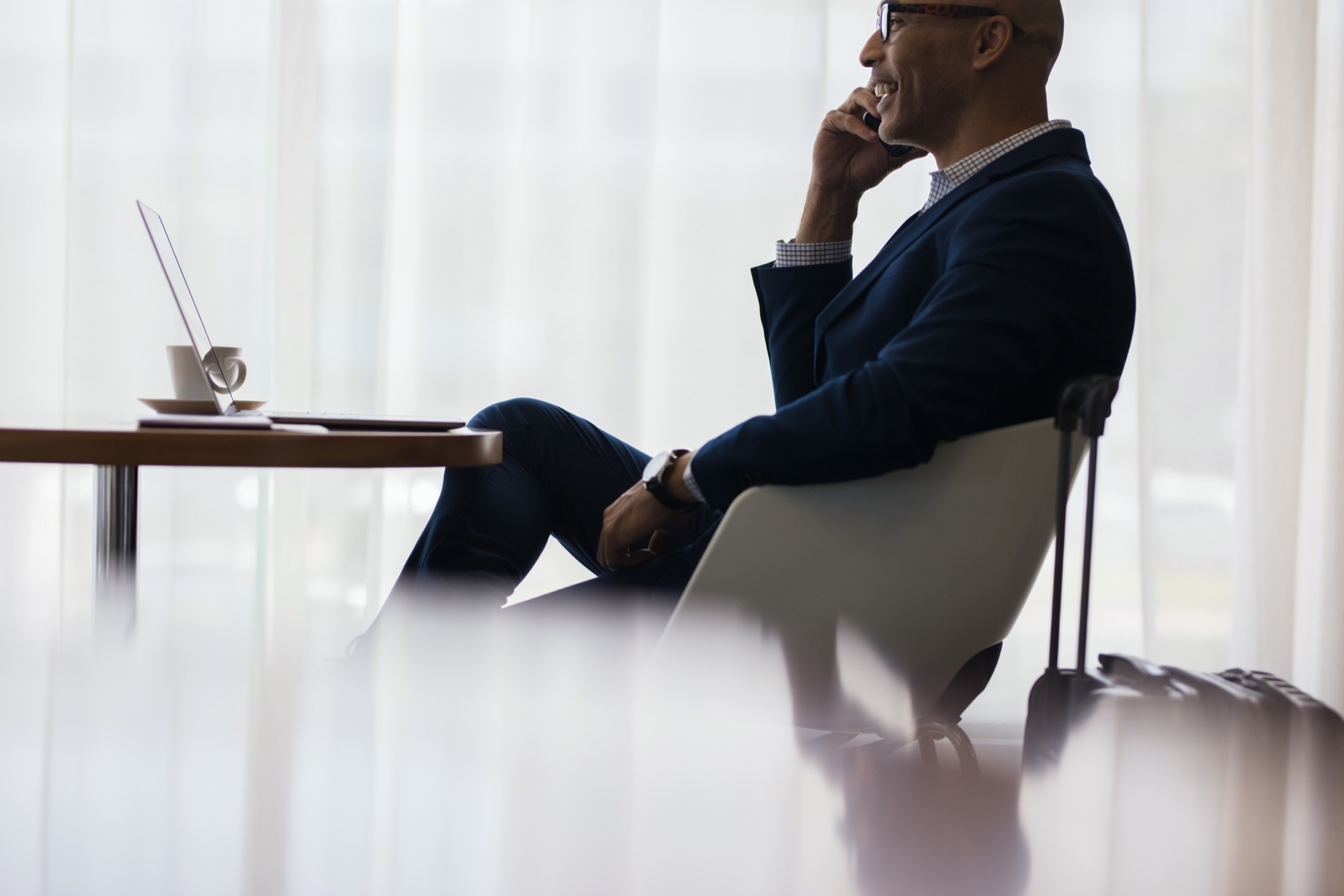 Business traveler making a phone call from airport lounge