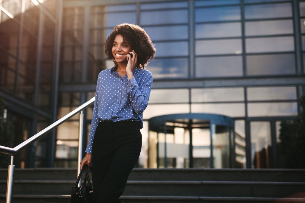 Businesswoman walking outdoors talking on cell phone
