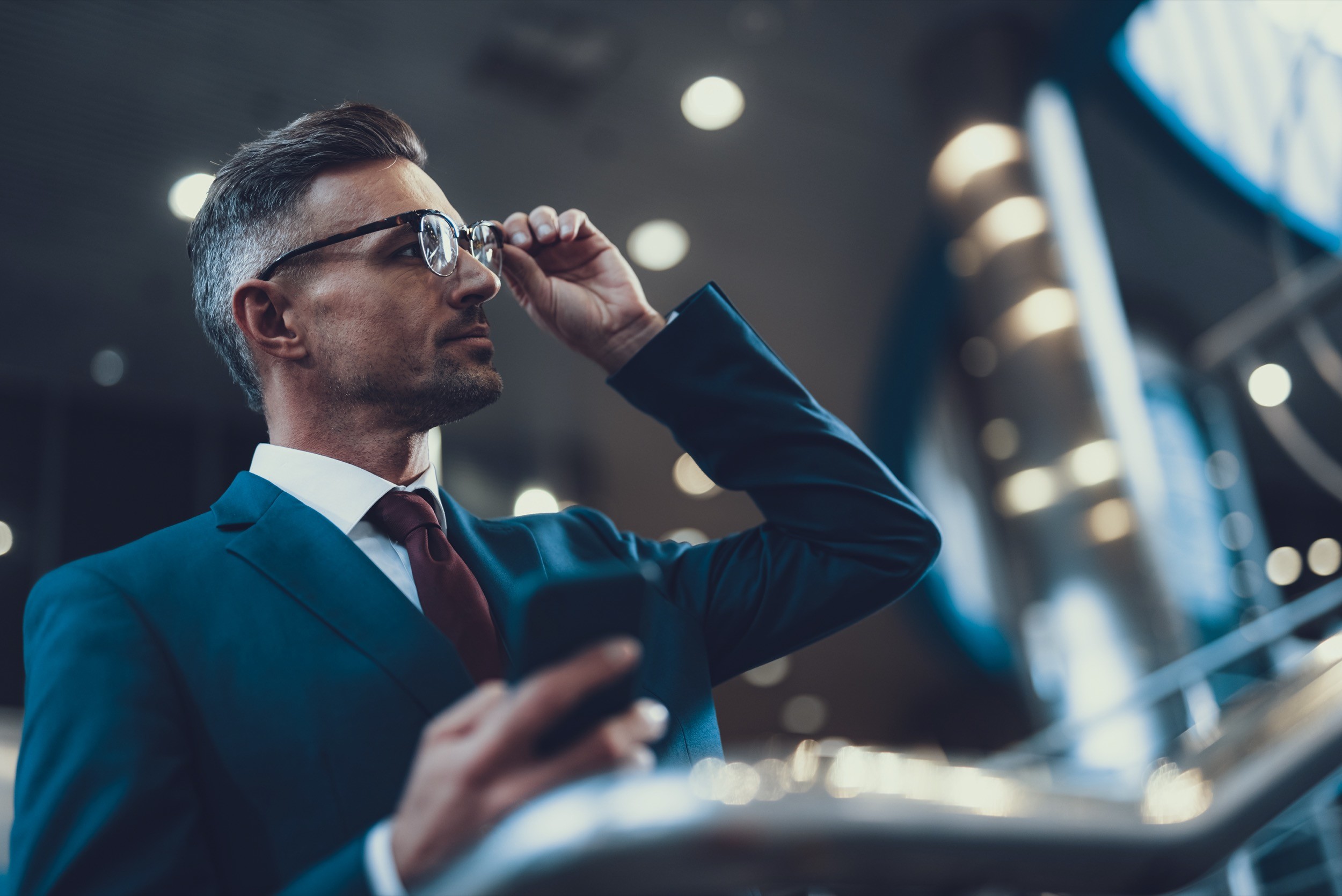 Man correct glasses and holding telephone in hand