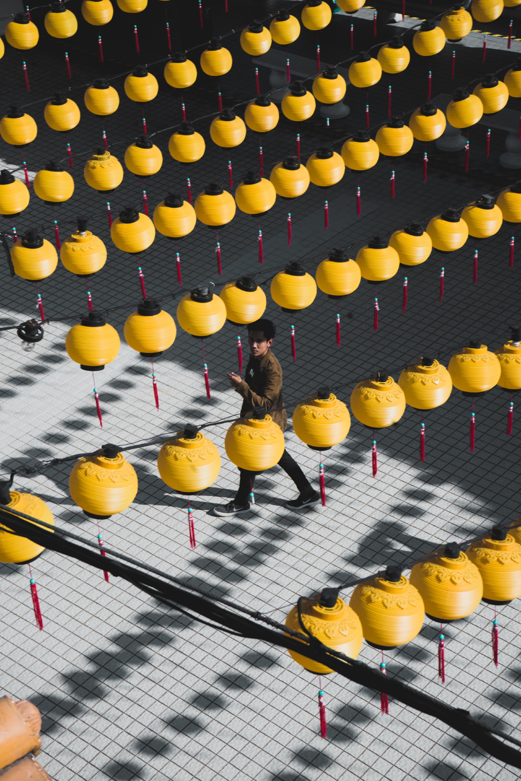 man-walking-under-yellow-string-lights-3576265