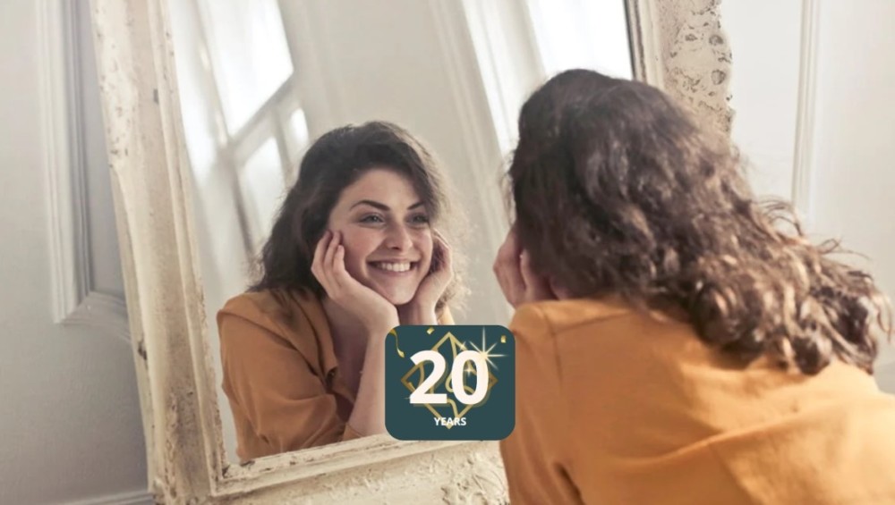 A woman smiling into the mirror 20 years.